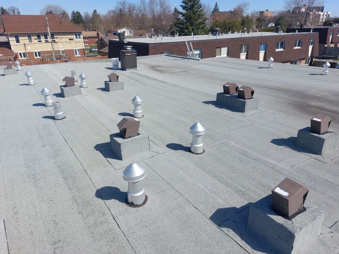 Preventative-maintenance work completed by Brandon on a flat roof with vent stacks and raised rooftop curbs